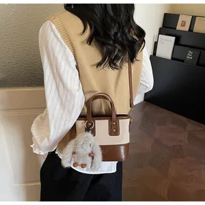 Vista dettagliata della borsa a tracolla retrò da donna a contrasto con grazioso ciondolo.