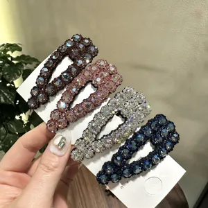 Primo piano di lussuosi fermagli per capelli con strass in quattro colori, accessorio chic.