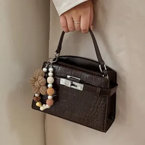 Dark brown crocodile texture top handle handbag with cute pearl and knitted flower bag charm.