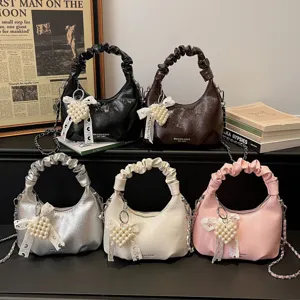 Stylish women's ruched handle handbag with elegant pearl heart charm and chain crossbody strap.