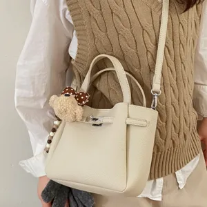 Off-white leather commuter shoulder bag with cute plush bear charm, stylish daily crossbody bag.