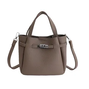 Elegant brown leather bucket handbag with metal lock and shoulder strap for women commute.