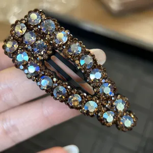 Dettaglio ravvicinato di forcina BB con strass scintillanti e cristalli champagne base.