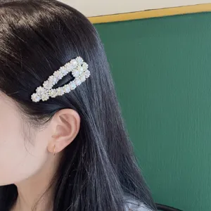 Primo piano dettagliato di una molletta per capelli con strass scintillanti sui capelli scuri.