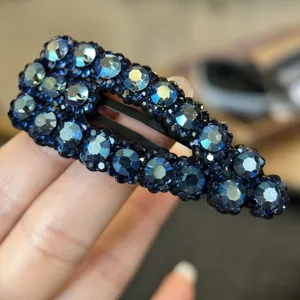 Primo piano sul dettaglio del fermaglio per capelli con strass blu, cristallo lucido.