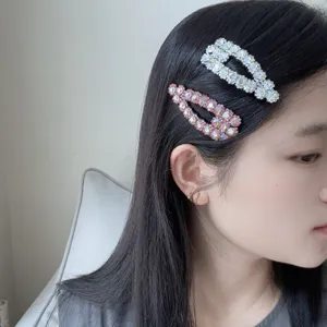 Primo piano di mollette per capelli con strass scintillanti indossate lateralmente.