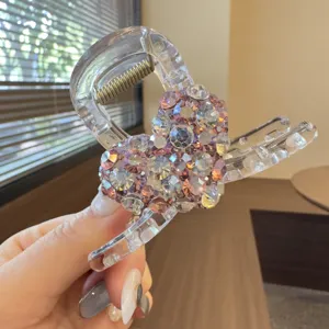 Close-up detail of rhinestone heart hair claw clip, sparkling crystal pink hair accessory.