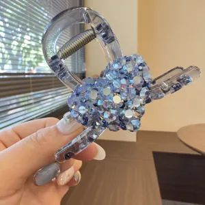 Closeup detail of the blue rhinestone heart hair claw clip, sparkling crystal acrylic design.