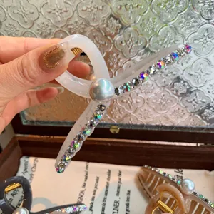 Pince à cheveux en acrylique blanc translucide style coréen avec strass et perle.