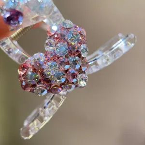 Transparent acrylic hair claw clip featuring a sparkly pink rhinestone heart design for women.