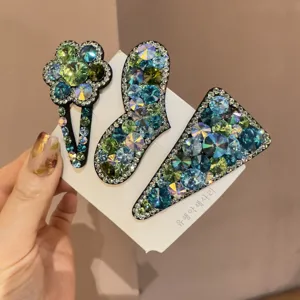 Vue de détail des pinces à cheveux strass cristal bleu et vert présentées sur carte.