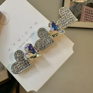 Gros plan d'une pince à cheveux cœur en strass doux avec des cristaux brillants et métal.