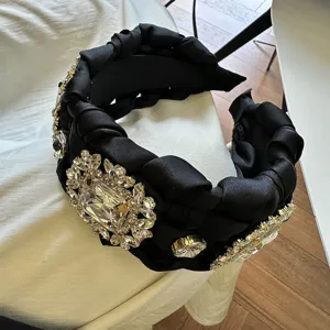 Diadema negra trenzada con brillantes pedrería de cristal, vista detallada de cerca.