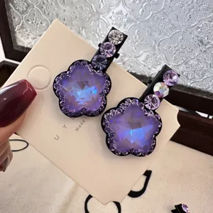 Gros plan détaillé d'une jolie pince à cheveux fleur en cristal violet étincelant.