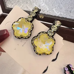 Gros plan détaillé de la pince à cheveux brillante en strass jaune, beaux détails de cristal.