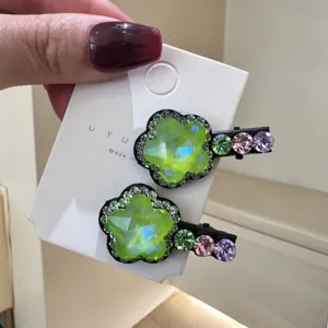 Vue détaillée de jolies pinces à cheveux cristal étoile et fleur avec strass colorés.