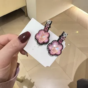Vue détaillée de pinces à cheveux étoiles en strass rose doux avec carte blanche, design élégant.