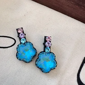 Gros plan detail de la pince a cheveux fleur en strass scintillante avec cristaux et base.