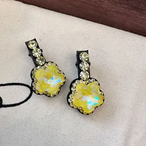 Gros plan sur la pince à bec de canard en cristal jaune, accessoire de cheveux floral.