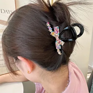 Vue détail pince à cheveux nœud strass, griffe cheveux cristal coloré pour chignon de femme.