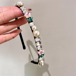 Detailed detail shot of thin black rhinestone and pearl headband, beautiful hair accessory.