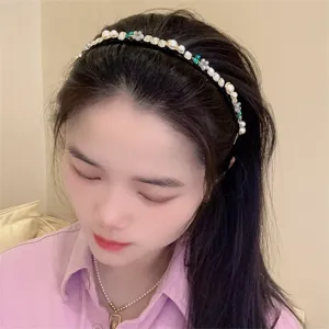 Exquisite thin black headband adorned with pearls, rhinestones, and cute little green floral details.