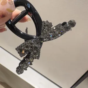 Gros plan détaillé d'une élégante pince à cheveux nœud papillon avec des strass brillants.