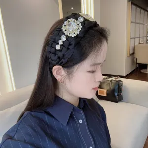Vista detallada de diadema negra trenzada con pedrería, accesorio de cabello elegante