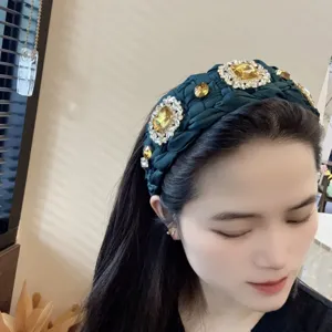 Detalle de diadema trenzada verde, pedrería de lujo y accesorio de pelo de cristal.