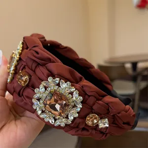 Primer plano de diadema trenzada ancha adornada con pedrería brillante y diseño de lujo.