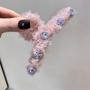 Vista detallada de pinza para pelo de malla rosa con cristales morados y flores para peinado elegante.