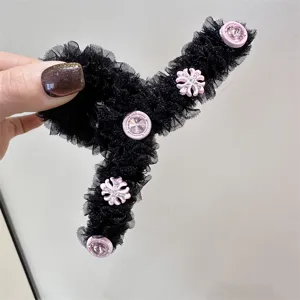 Pinza de pelo de malla negra con detalles florales de estrás rosa, vista de detalle.