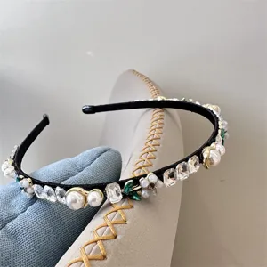 Delicate crystal and pearl headband detail shot, featuring sparkling rhinestones and elegant pearls.