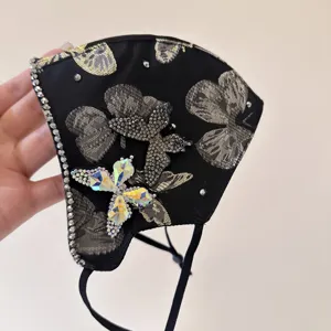 Fashion black face mask with gold butterfly patterns and sparkling crystal rhinestones accessory.