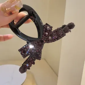 Pince à cheveux noire élégante avec strass violet, design de nœud chic pour un usage quotidien.