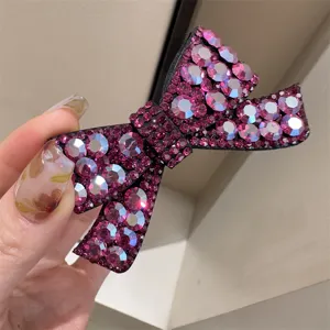 Gros plan d'une superbe pince à cheveux nœud en strass magenta aux détails étincelants.