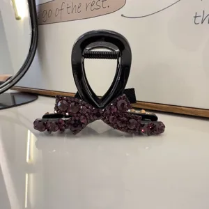 Élégante pince à cheveux noire avec nœud en strass violets étincelants, accessoire de coiffure.