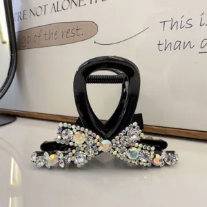 Vue détail pince à cheveux nœud strass noirs, cristaux étincelants, accessoire élégant.
