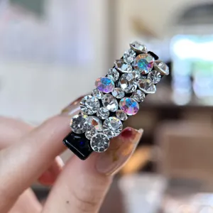 Vue détaillée d'une petite pince à cheveux brillante en strass style bec de canard.
