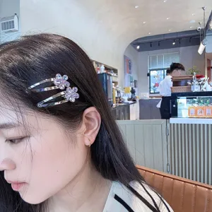 Détail de pince à cheveux fleur de cristal, montrant les strass et la structure en métal.