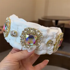 Primer plano detallado de la diadema blanca trenzada de lujo con pedrería colorida.