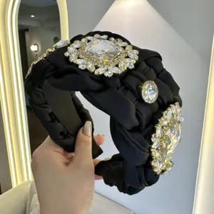 Vista detallada de diadema ancha negra trenzada con pedrería, accesorio de pelo de lujo elegante.
