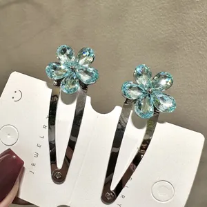 Gros plan détaillé de pinces à cheveux en cristal bleu, strass scintillants, jolie barrette.