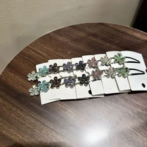Vue détaillée de pinces à cheveux strass fleurs sur des cartes blanches de présentation.
