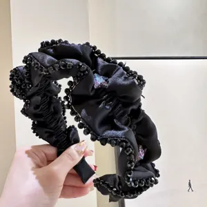 Elegantes schwarzes Rüschenstirnband mit funkelnden Perlen und glänzenden Sternkristallen.