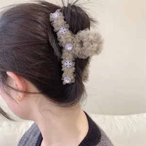 Primer plano de una pinza de pelo de malla decorada con flores y finos detalles de pedrería.