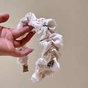 Weißes gerüschtes Haarband mit Kristallperlen im Detail, elegantes Haaraccessoire für Damen.