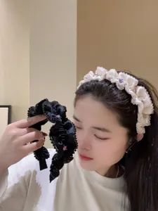 Nahaufnahme eines stilvollen, plissierten Perlen-Haarreifs, elegantes Haaraccessoire.