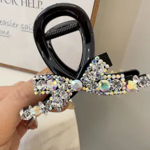 Gros plan d'une pince a cheveux noeud cristal noir avec des strass scintillants.