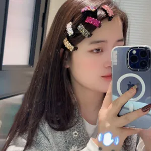 Vue détaillée de pinces à cheveux étincelantes en strass sur le côté, accessorio mignon et brillant.
